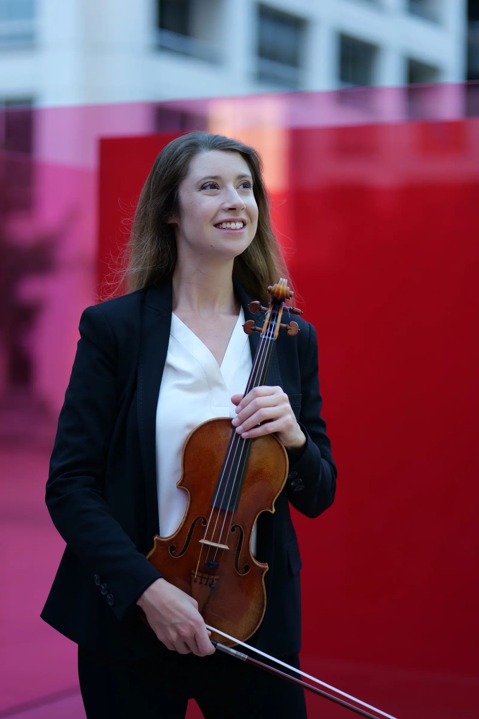 Madalyn smiling with her violin at the Bill and Coo installation, Downtown Los Angeles
