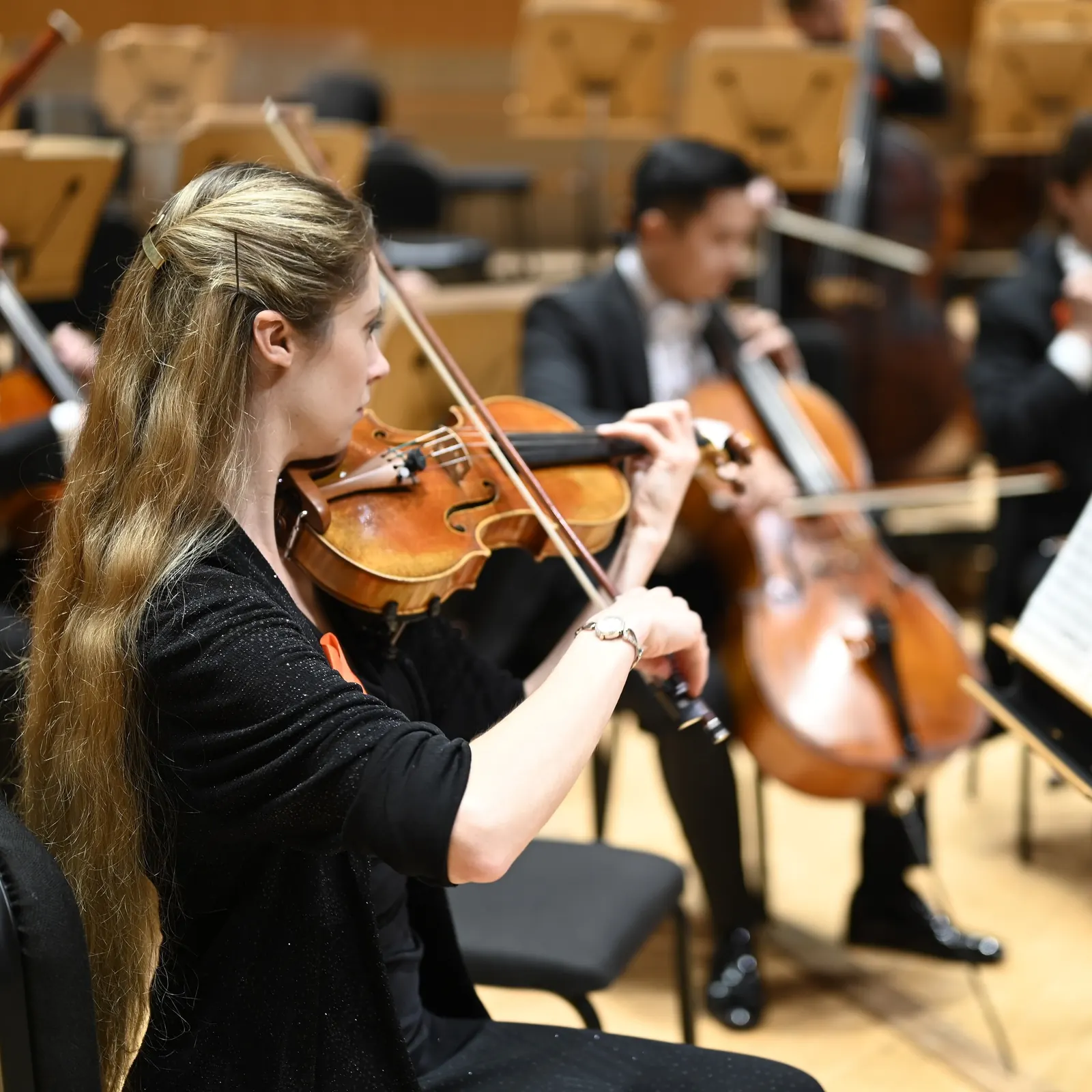Madalyn performing within the Pacific Symphony, cello section behind her